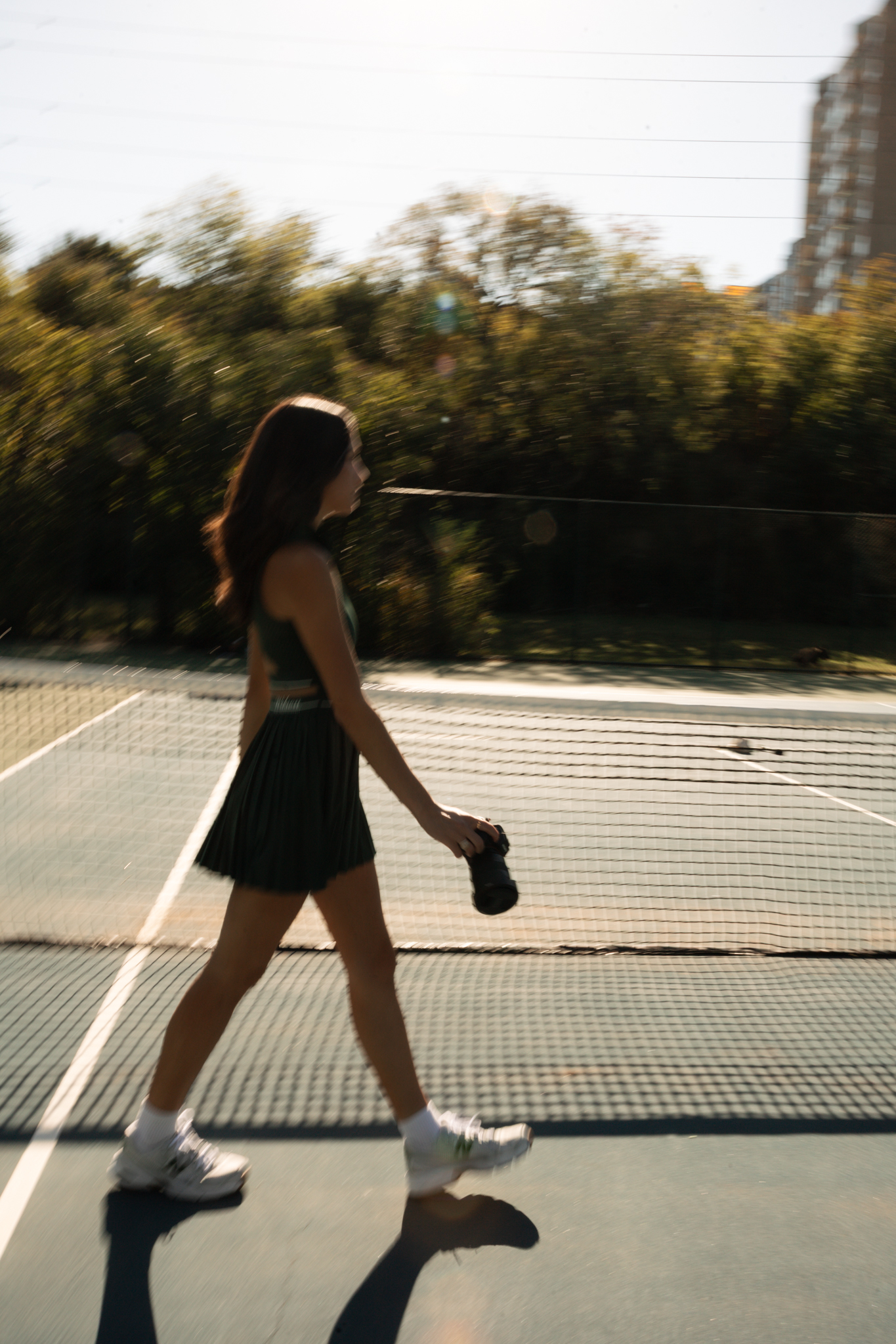 Photographer walking beside a tennis court